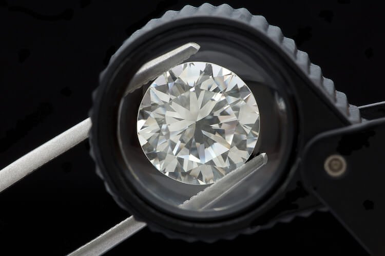 Diamanten Schliff unterschiedlicher Schliffgrade auf Bildern - Ein Diamant bei seiner Prüfung eingeklemmt in einer Pinzette